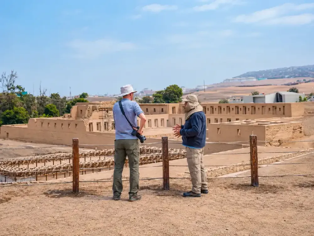 Guía explicando la historia del Acllahuasi a un turista en el Santuario de Pachacámac.
