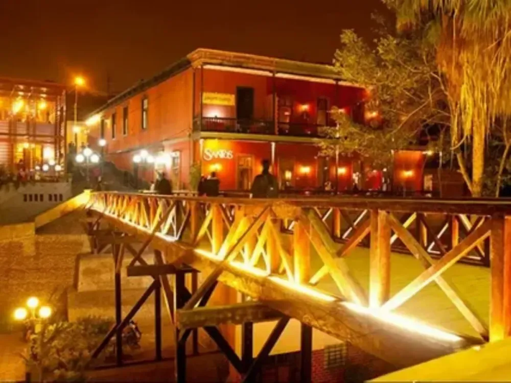 Puente de los Suspiros iluminado frente al restaurante Santos en Barranco 