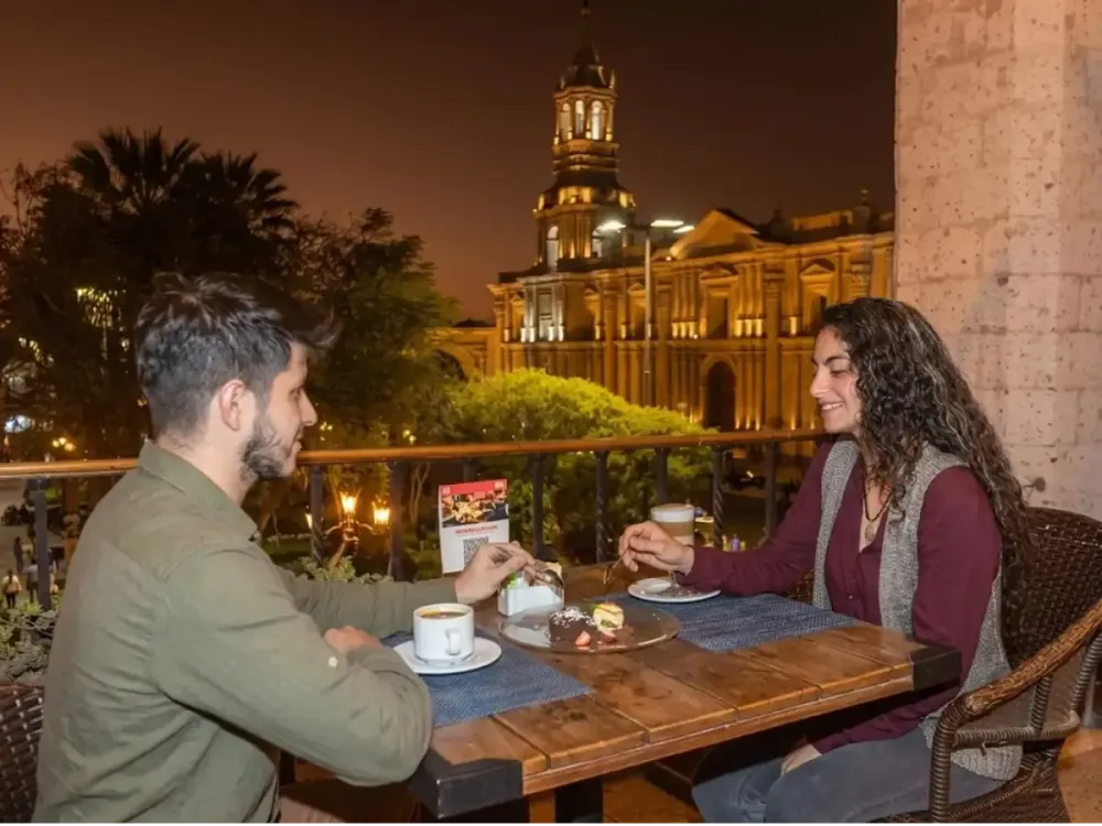 Pareja comparte un postre en una terraza frente a la Catedral de Arequipa