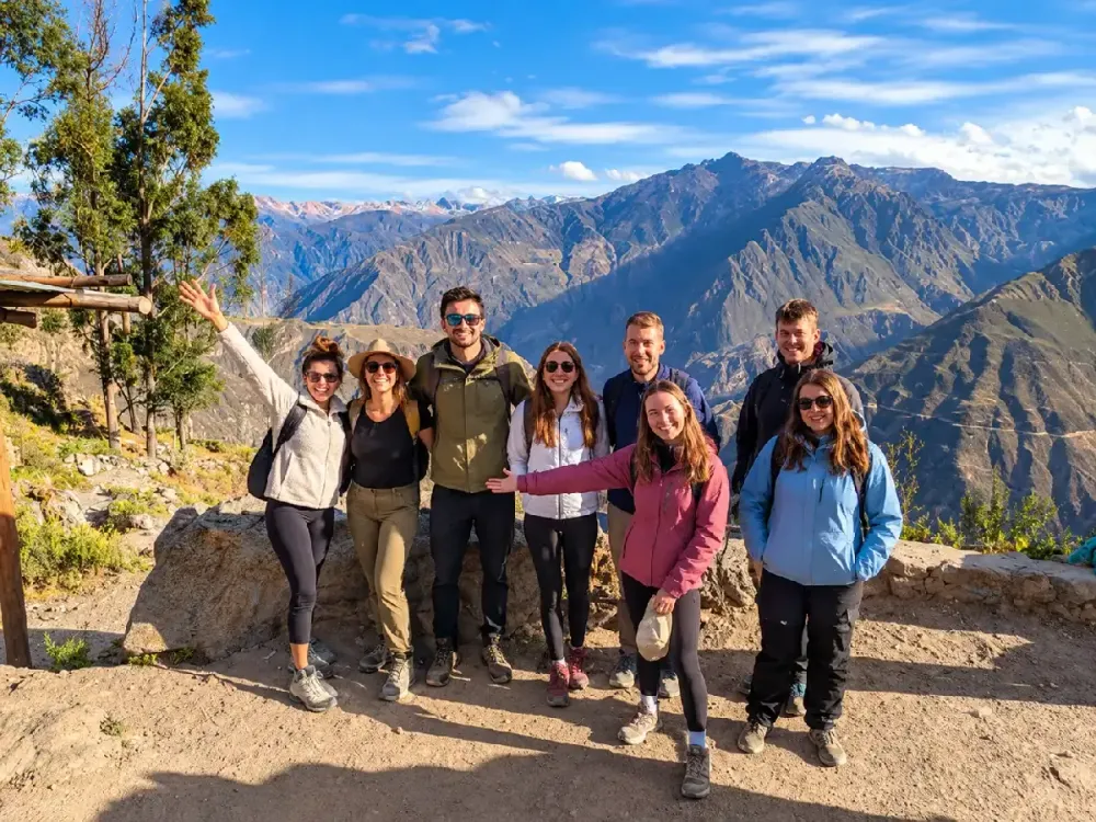 Grupo de excursionistas sonríe en un mirador frente al Cañón del Colca, Perú