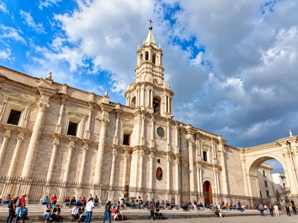 Fachada y torre de la Catedral de sillar de Arequipa bajo un cielo nublado