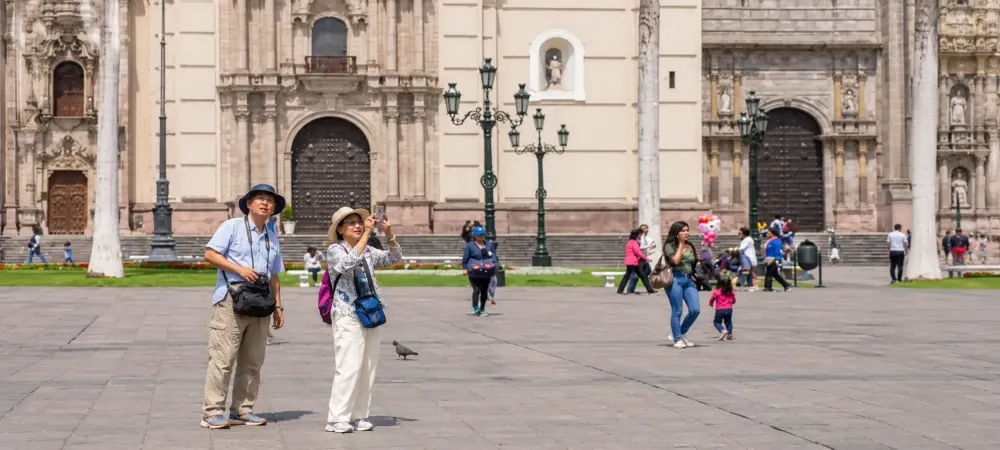 Turistas tomando fotos en la Plaza Mayor de Lima frente a la Basílica Catedral.