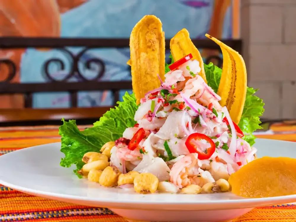 Ceviche carretillero peruano con chifles, cancha serrana y camote en plato blanco.