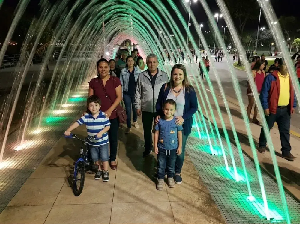 Familia posando bajo el túnel de agua iluminado del Circuito Mágico