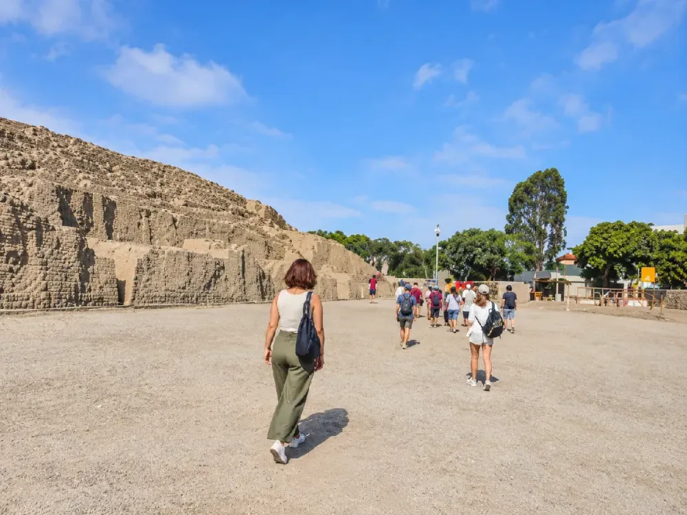 Grupo de turistas recorriendo la Huaca Pucllana bajo un cielo despejado