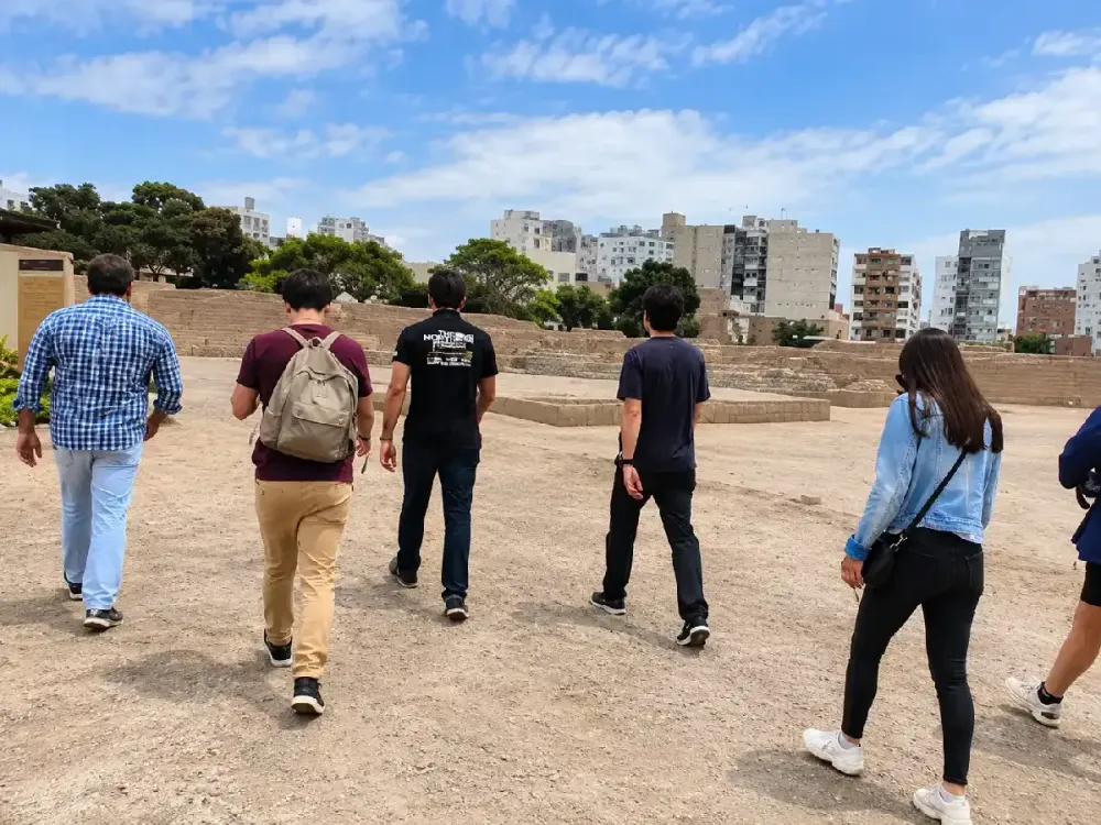 Turistas con mochilas recorriendo a pie el sitio arqueológico Huaca Pucllana