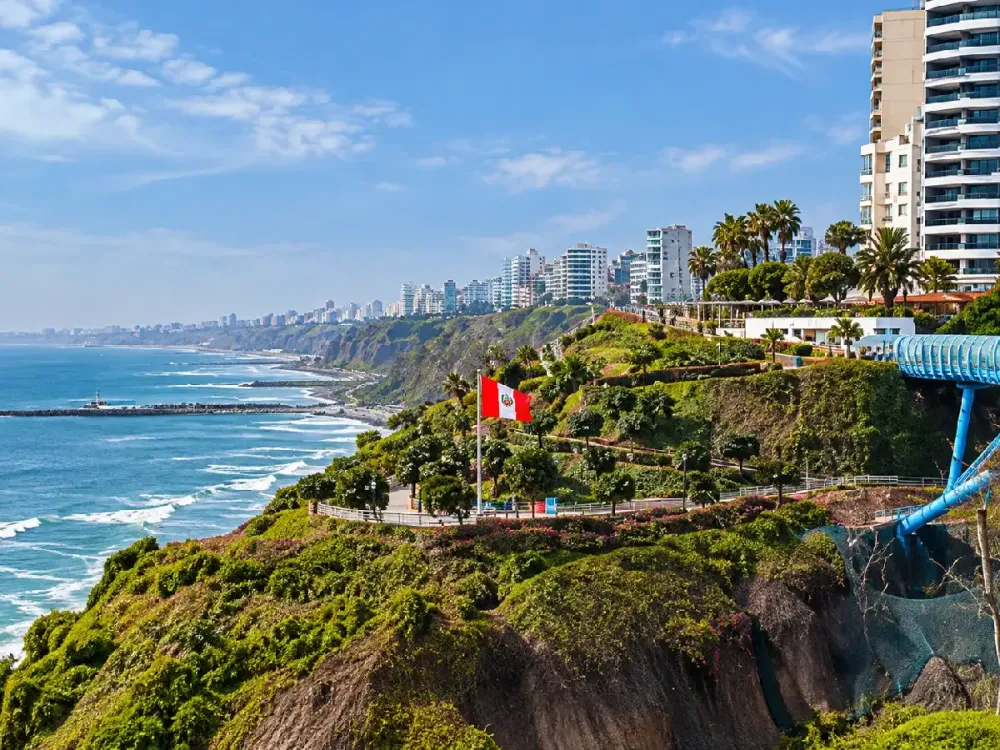 Bandera peruana ondeando en el Malecón de Miraflores con vista a la Costa Verde.