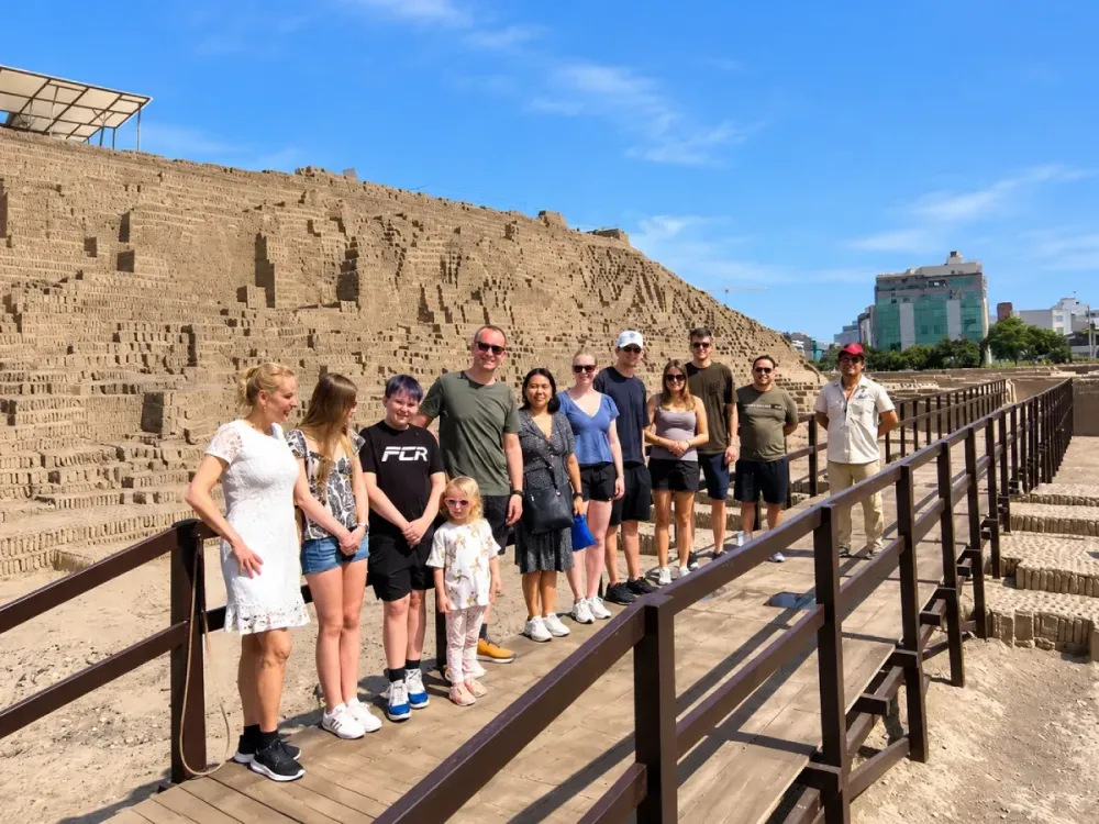 Grupo de turistas posando junto a un guía en las ruinas de Huaca Pucllana