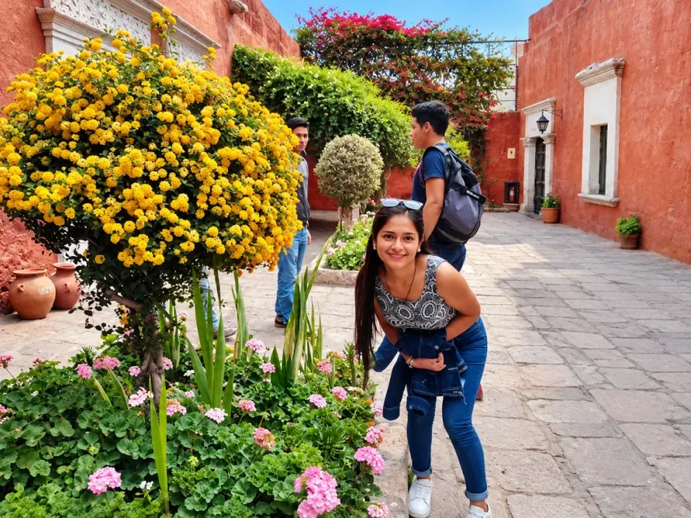 Chica sonríe junto a un gran arbusto de flores amarillas en un patio rojo