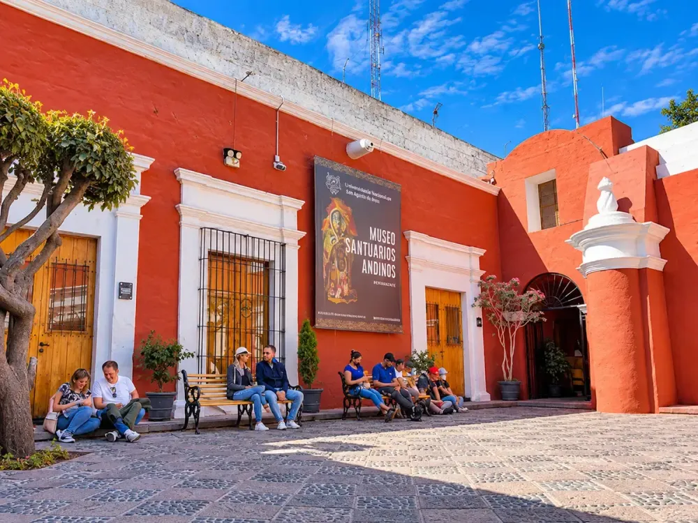 Turistas descansando en la fachada del Museo Santuarios Andinos de Arequipa
