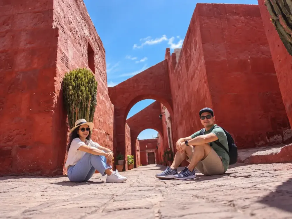 Pareja sentada en el suelo de una calle roja del Monasterio de Santa Catalina