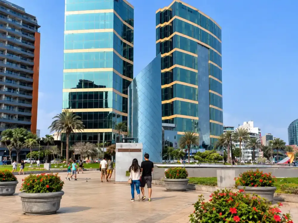 Pareja paseando frente a las torres vidriadas del JW Marriott en el Parque Salazar.