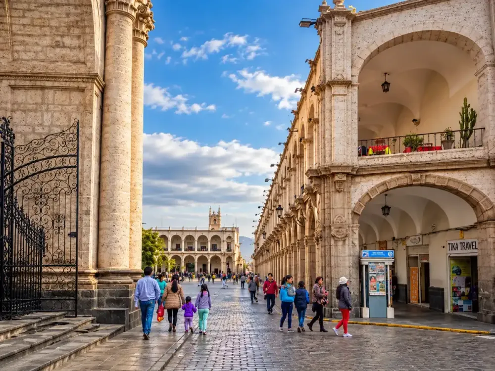 Turistas pasean por una calle de sillar junto a los portales de Arequipa.