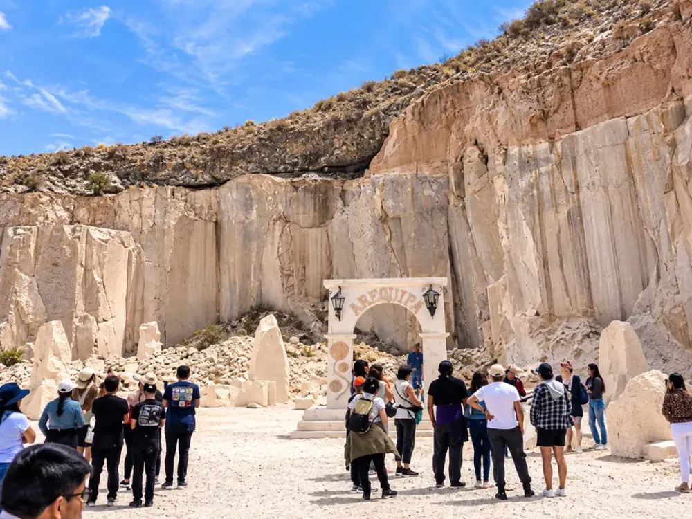 Turistas frente a un arco labrado en las canteras de la Ruta del Sillar