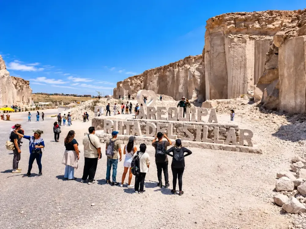 Turistas frente al gran letrero tallado de la Ruta del Sillar en Arequipa