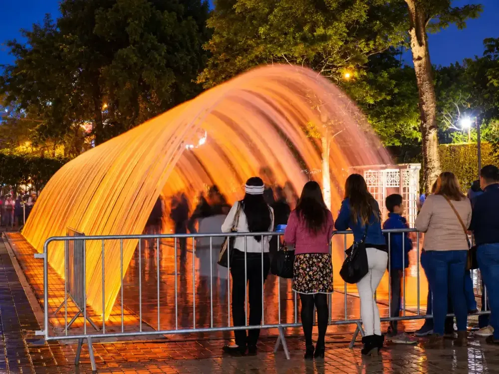 Personas observando el túnel iluminado de la Fuente de la Fantasía en Lima.