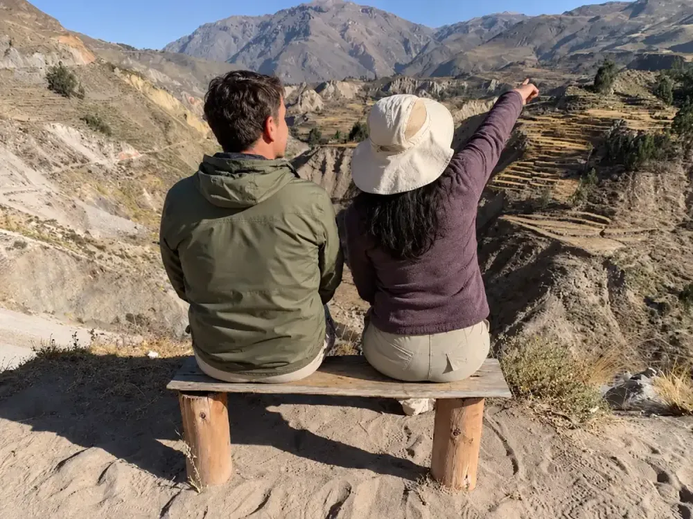 Pareja en un banco observa las terrazas agrícolas del Valle del Colca, Perú