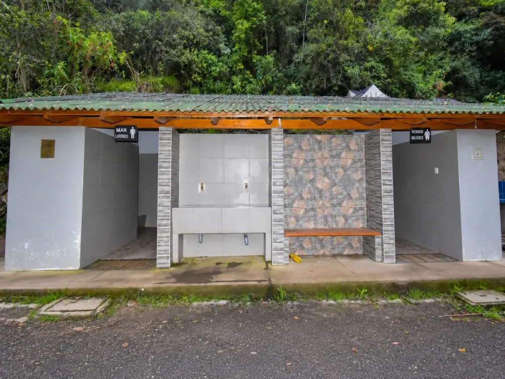 Baños públicos con lavamanos disponibles durante el recorrido del Camino Inca a Machu Picchu, rodeados de vegetación.
