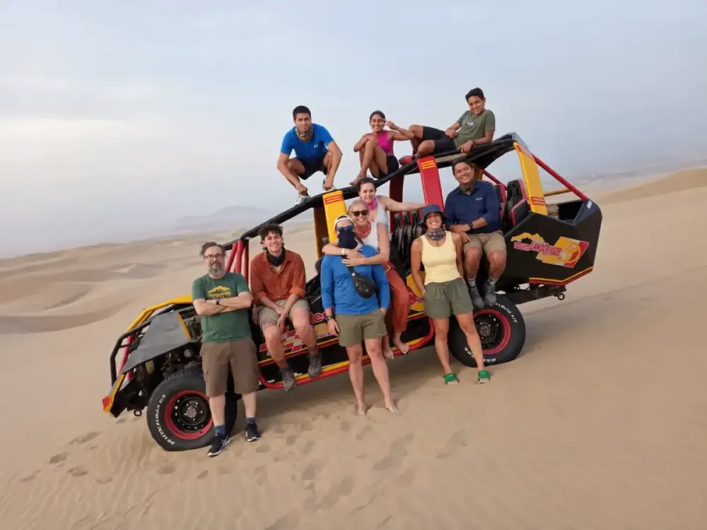 Grupo de turistas disfrutando de un paseo en buggy por las dunas de Huacachina, Ica, Perú.