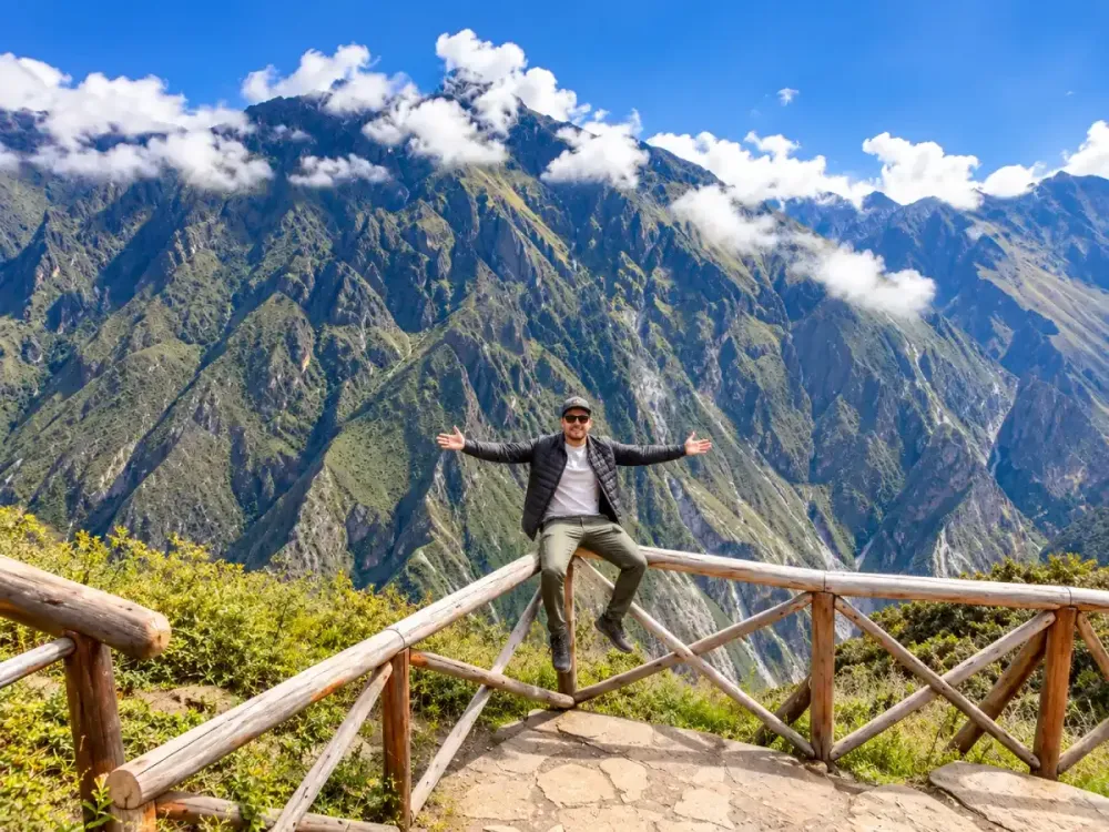 Viajero sentado en baranda de madera en el Mirador de San Miguel, Colca, Arequipa
