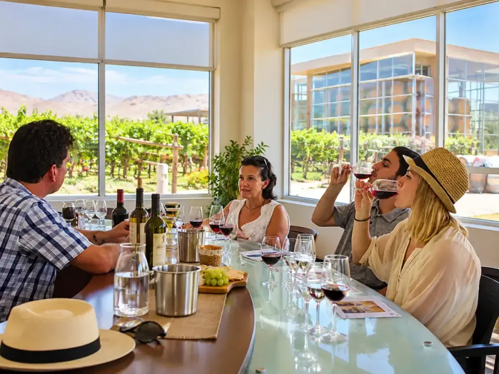 Alt: Turistas participando en una cata de vinos en una bodega de Ica, Perú.