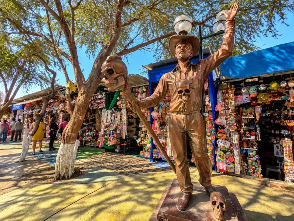 Estatua tradicional y puestos de artesanía en el pueblo de Cachiche, Ica, Perú