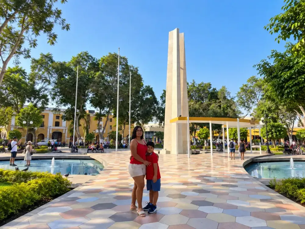 Turistas visitando la Plaza de Armas de Ica, Perú, con su monumento central y jardines.