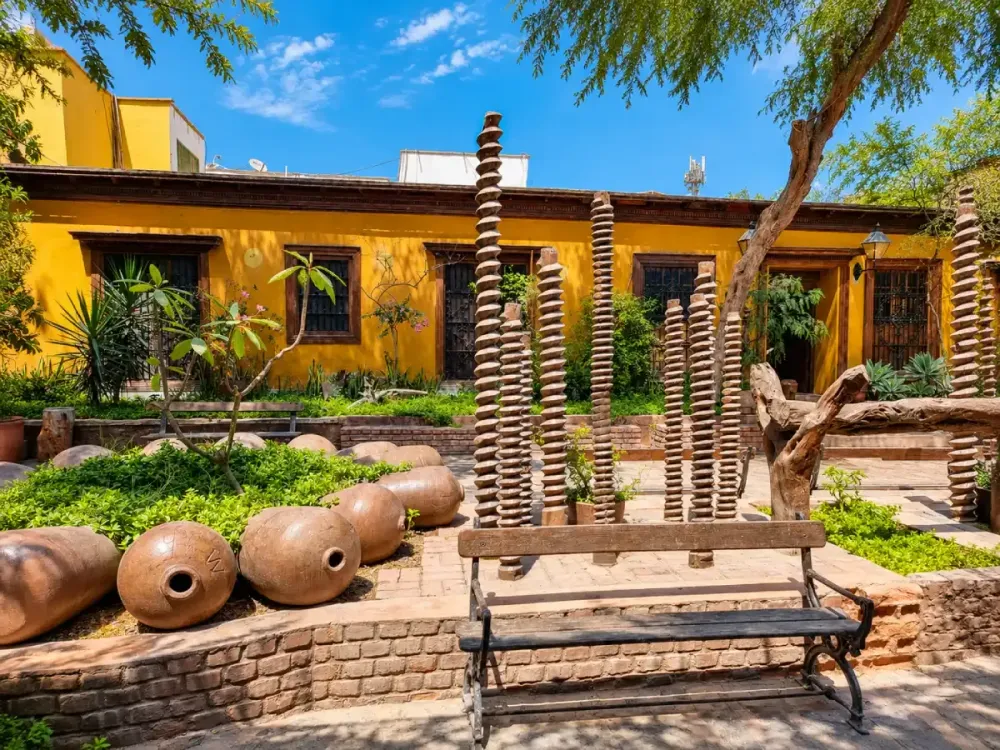 Bodegas tradicionales de Ica con tinajas de barro, jardines y arquitectura típica de la región.