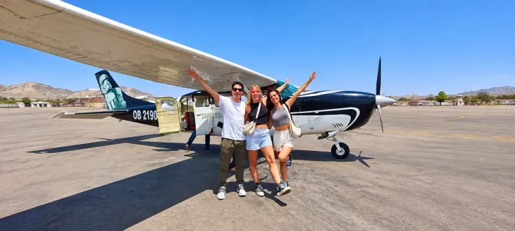 Turistas junto a una avioneta antes del sobrevuelo de las Líneas de Nazca, Perú.