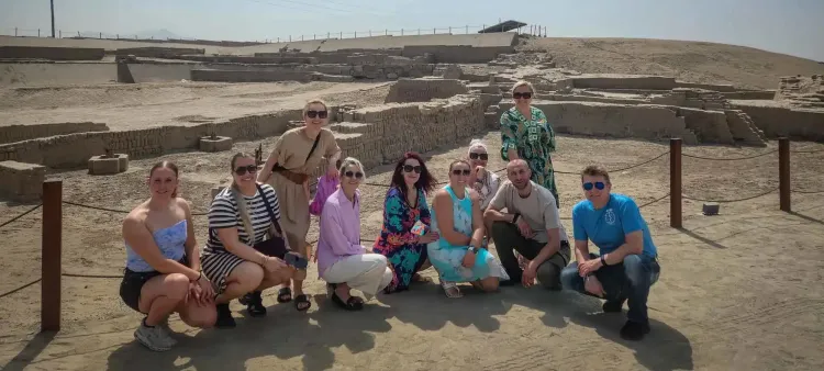 Grupo de turistas posando durante una visita guiada en el Santuario Arqueológico de Pachacámac.